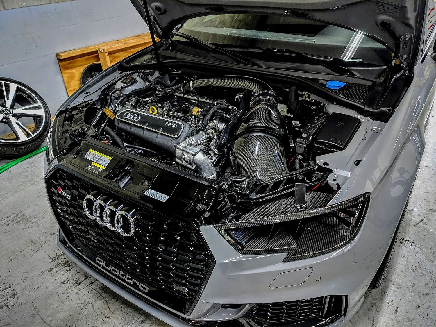 An Audi RS3 engine bay with a carbon intake, open on a bench at RSP Automotive Solutions