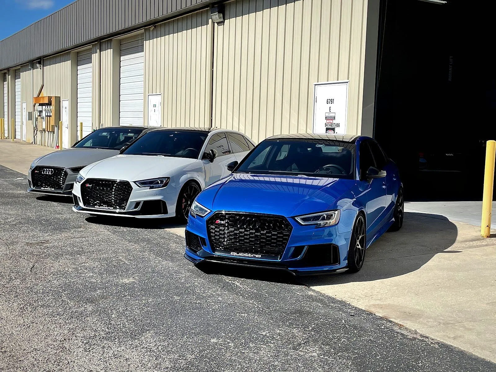 Three Audi RS3s parked outside the RSP Automotive Solutions workshop in Sarasota