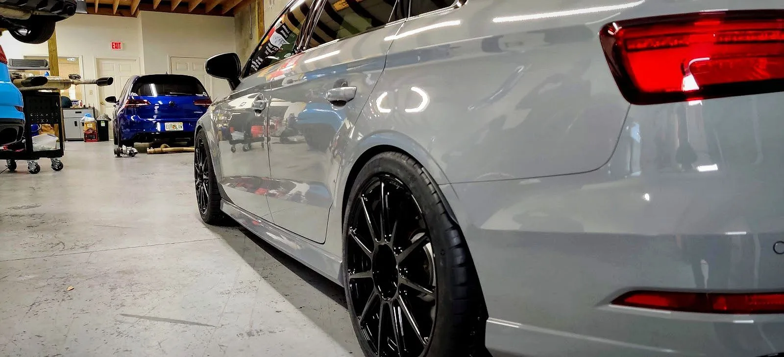 A Nardo grey Audi sedan on lowered wheels inside the RSP workshop